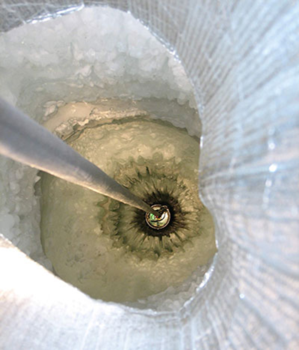 A photodetector being lowered into a hole opened in the ice at the South Pole.