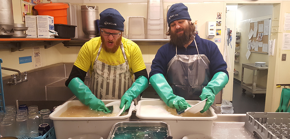 皿洗いのボランティアをしているメンバー